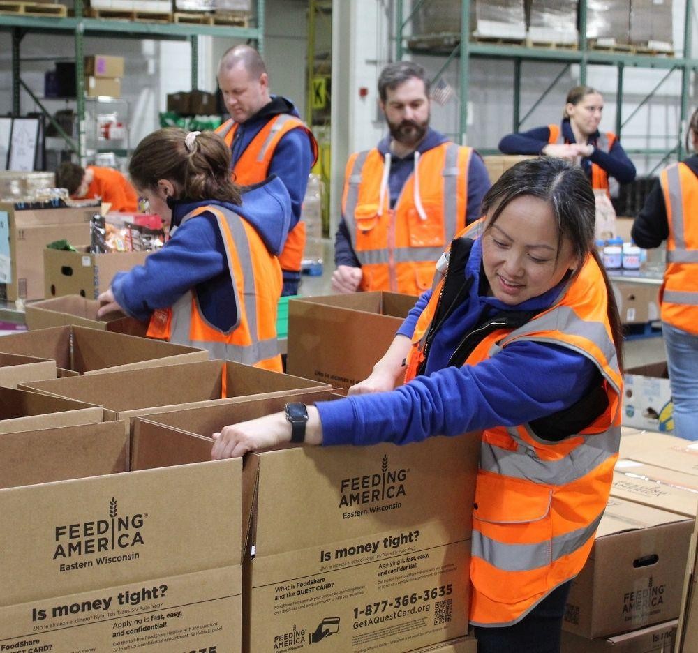 Volunteers in safety vests packing boxes at Feeding America Eastern Wisconsin