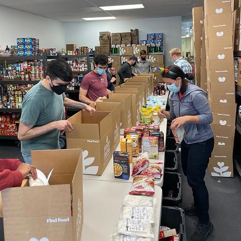 Volunteers packing grocery boxes at a food pantry